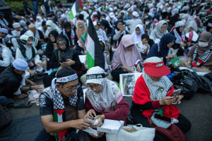 Protesters are having their Iftar meals to break their fast during a mass Iftar dinner organized for displaced Palestinians in Jakarta, Indonesia, on April 7, 2024 (Photo:  Afriadi Hikmal/NurPhoto/Via REUTERS).
