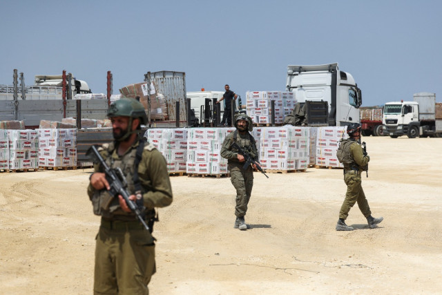 Israeli soldiers secure humanitarian aid, amid the ongoing conflict in Gaza between Israel and the Palestinian Islamist group Hamas, near the Erez Crossing point in northern Gaza, May 1, 2024 (Photo: EUTERS/Ronen Zvulun).