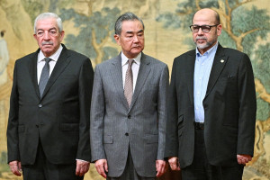 Mahmoud al-Aloul, Vice Chairman of the Central Committee of Palestinian organisation and political party Fatah, China's Foreign Minister Wang Yi, and Mussa Abu Marzuk, senior member of the Palestinian terrorist group Hamas, attend an event at the Diaoyutai State Guesthouse in Beijing on July 23, 2024 (PEDRO PARDO/Pool via REUTERS).
