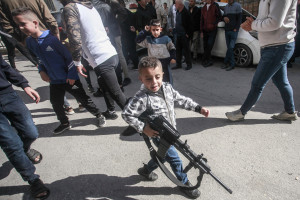 A Palestinian child holds a plastic gun during the funeral in Ein Beit al-Maa camp. 21 Nov 2024. (Photo: Reuters)