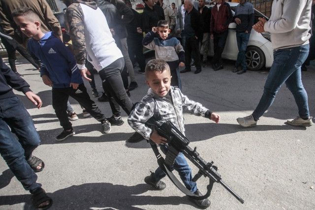 A Palestinian child holds a plastic gun during the funeral in Ein Beit al-Maa camp. 21 Nov 2024. (Photo: Reuters)