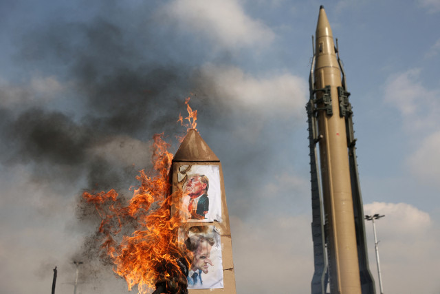 Iranians burn caricatures of U.S. President Donald Trump and French President Emmanuel Macron during the 46th anniversary of the Islamic Revolution in Tehran, Iran, February 10, 2025. Photo via REUTERS