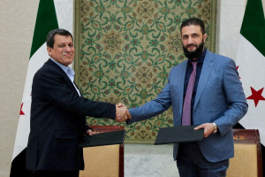 Syria's interim President Ahmed al-Sharaa and Commander of Syrian Kurdish-led forces Mazloum Abdi shake hands, after Syria reached a deal to integrate the Kurdish-led Syrian Democratic Forces (SDF) with state institutions. Damascus, Syria, March 10, 2025. SANA/Handout via REUTERS