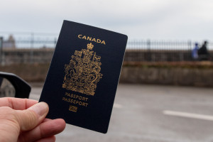 A passenger’s hand holds up a Canadian passport , Canada, 15 Mar 2025 Photo: Reuters Connect