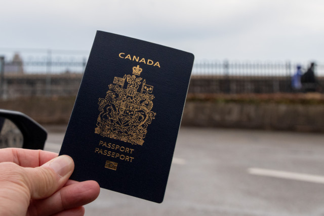 A passenger’s hand holds up a Canadian passport , Canada, 15 Mar 2025 Photo: Reuters Connect