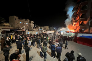 People gather as smoke rises following an Israeli airstrike at Nasser hospital, according to the Palestinian civil defence, in Khan Younis in the southern Gaza Strip March 23, 2025. REUTERS/Hussam Al-Masri
