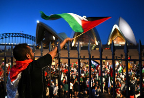 A demonstrator waves a flag during a pro-Palestinian rally near the Sydney Opera House in Sydney, Australia, October 9, 2023. AAP/Dean Lewins/via REUTERS