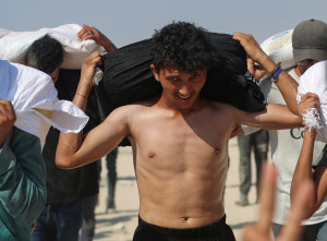 Palestinians carry aid supplies that entered Gaza through Israel, in Beit Lahia, northern Gaza Strip, August 2, 2025. REUTERS/Mahmoud Issa
