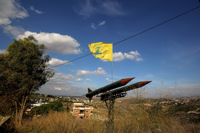 A pro-Iranian Hezbollah flag flutters over replica of missiles pointed towards Israel in the southern Lebanese village of Burj Qalaway. November 17, 2025 Photo: Marwan Naamani by Reuters Connect