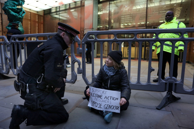 Swedish activist Greta Thunberg speaks to a police officer during a pro-Palestinian protest as she holds a sign that says she supports prisoners linked to Palestine Action, an organisation which the British government has proscribed as a terrorist group, in London, Britain, December 23, 2025. (Photo: Prisoners for Palestine/Handout via Reuters)