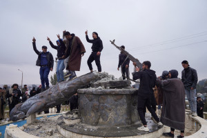 A group of civilians smash a statue of a Syrian Democratic Forces fighter in the city of Tabqa after the Syrian army took control of it, in Tabqa, Syria, January 18, 2026. Photo: Reuters Connect by Karam al-Masri