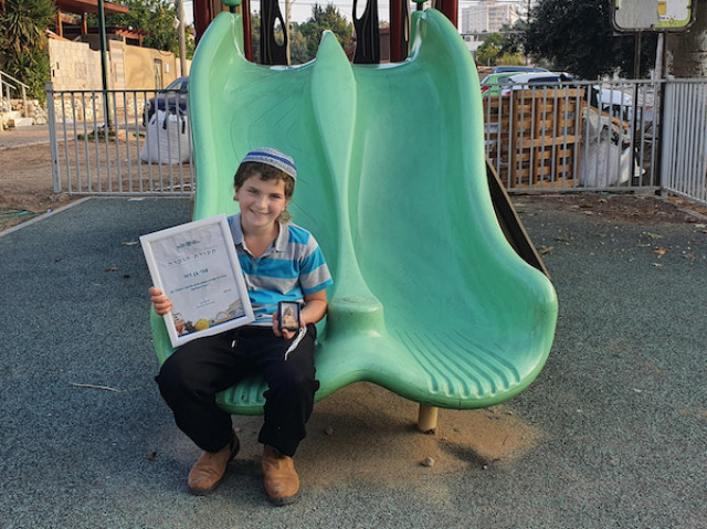 Zvi Ben-David holding the figurine and a certificate of appreciation. (Photo: Oren Shmueli/ Israel Antiquities Authority)