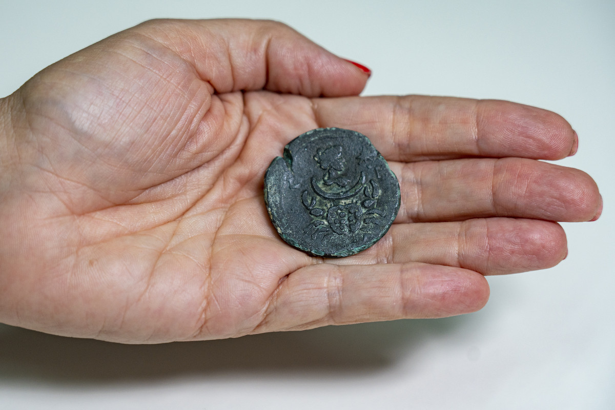 The coin bearing the image of Luna, the goddess of the moon. Below it appears a sign of cancer luck. Photo: Yaniv Berman, Israel Antiquities Authority