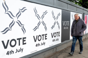 A man walks past a sign during the general election in Edinburgh, Scotland, July 4, 2024. (Photo: Reuters/Lesley Martin)