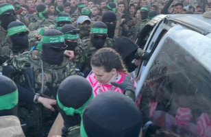 Hamas militants hand over Doron Steinbrecher, a hostage who had been held in Gaza since the deadly October 7 2023 attack, to members of the International Committee of the Red Cross (ICRC) as part of a ceasefire and a hostages-prisoners swap deal between Hamas and Israel, in Gaza City, January 19, 2025 (Photo: Screenshot/REUTERS)