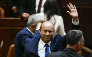 Newly elected Prime Minister Naftali Bennett waves after their new coalition wins Knesset approval, June 13, 2021 (Photo: Haim Zach/GPO)