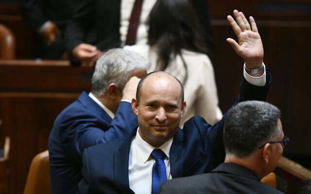 Newly elected Prime Minister Naftali Bennett waves after their new coalition wins Knesset approval, June 13, 2021 (Photo: Haim Zach/GPO)