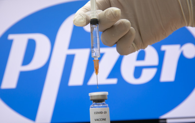 A photo illustration of a syringe and and a bottle reading "Covid-19 Vaccine" next to the Pfizer company logo in Jerusalem on December 10, 2020.
Photo by Olivier Fitoussi/Flash90