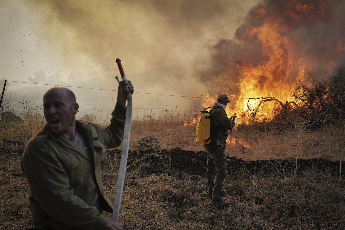 Israeli firefighters and civilians try to extinguish a fire which broke out from missiles and drones fired from Lebanon, at the Ein Kshatot National Heritage Site in Moshav Natur, Moshav Aniam , Golan Heights, July 4, 2024. (Photo by Michael Giladi/ Flash90)