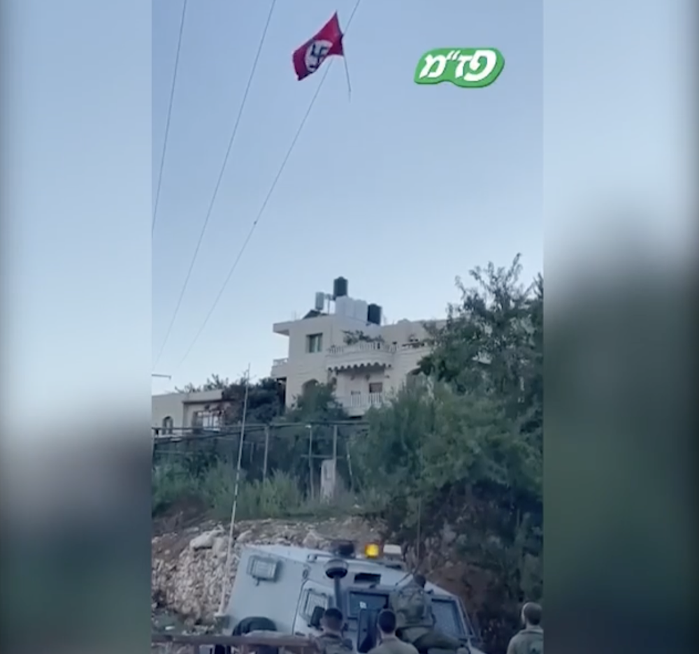IDF soldiers shoot down Nazi flag hung on an electrical wire by Palestinians in the West Bank village of Beit Ummar near Hebron, Sept. 25, 2021 (Photo: screenshot Instagram)