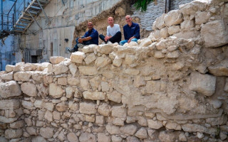 The excavation directors sitting on the exposed section of the first Temple-era protective wall on Jerusalem's eastern perimeter. (Photo: Yaniv Berman/Israel Antiquities Authority)