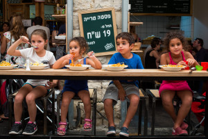 Illustrative: Young Israeli kids eat at a restaurant in the Mahane Yehuda in Jerusalem. Photo by Yonatan Sindel/Flash90