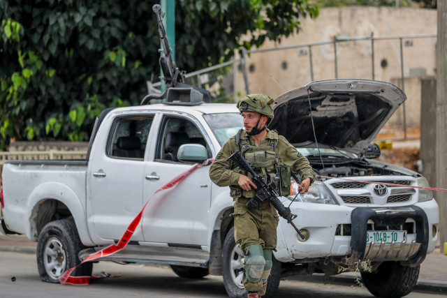 Israeli security forces stand next to a vehicle used by Hamas militants. Photo by Jamal Awad/Flash90