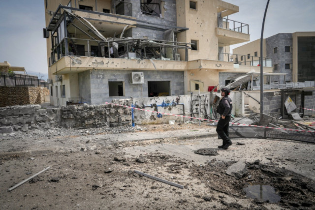 Israeli security forces look at the damage after a rocket fired from Lebanon hit the northern town of Kiryat Shmona, March 27, 2024 (Photo: Ayal Margolin/Flash90).