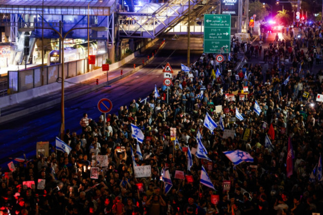 Demonstrators protest calling for the release of Israeli hostages held in the Gaza Strip seen blocking the Ayalon highway in Tel Aviv, May 6, 2024 (Photo: Chaim Goldberg/Flash90).