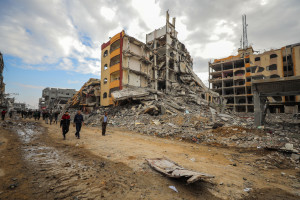Palestinians walk next to damaged buildings after the Israeli army withdrew from the area, in the Nuseirat camp, in the central Gaza Strip, on November 29, 2024. Photo by Ali Hassan/Flash90