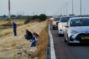 People take cover on the side of the road as siren warns of incoming missile fired from Yemen, on Road number 6 near Jaljulia, May 13, 2025. Photo by Ayal Margolin/Flash90
