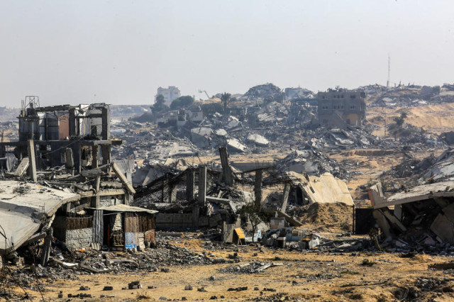 Palestinians walk past buildings destroyed in the recent war, in the Jorat al-Luth area, located between Rafah and Khan Younis in the southern Gaza Strip, November 10, 2025. Photo by Abed Rahim Khatib/Flash90