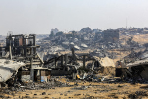 Palestinians walk past buildings destroyed in the recent war, in the Jorat al-Luth area, located between Rafah and Khan Younis in the southern Gaza Strip, November 10, 2025. Photo by Abed Rahim Khatib/Flash90