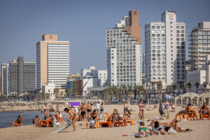 People enjoy the beach on a hot day in the end of fall, in Tel Aviv. November 23, 2025. Photo by Miriam Alster/FLASH90