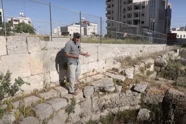 The archaeologist Joel Kramer standing in front of the Byzantine apse at the ancient Oaks of Mamre site (Screenshot from Joel Kramer's youtube channel)