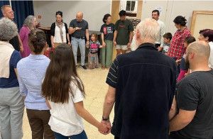 Israeli Messianic Jewish and Arab Christian believer families praying together.