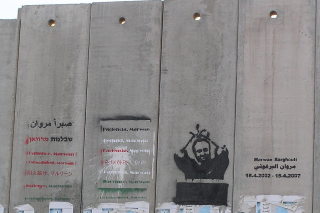 A mural of imprisoned Fatah leader Marwan Barghouti painted on the Israeli security barrier near the Qalandia checkpoint, north of Jerusalem. (Photo: Wikimedia Commons)