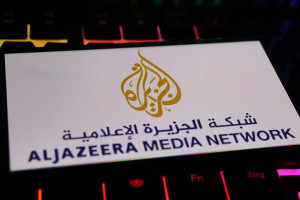 Illustrative image: Smartphone screen displaying the Al Jazeera Media Network logo, placed on a computer keyboard. Photo: Shutterstock.